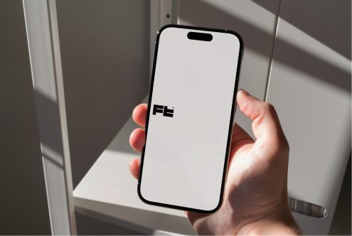 iPhone 14 Pro in hand displaying white screen, soft studio lighting