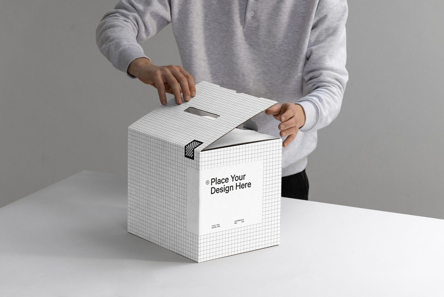 Person holding a customizable packaging box mockup with a place your design here label, ideal for product design presentations.