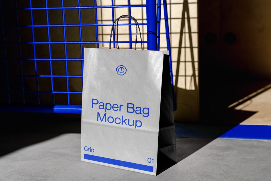 White paper shopping bag mockup with blue logo on blue grid backdrop