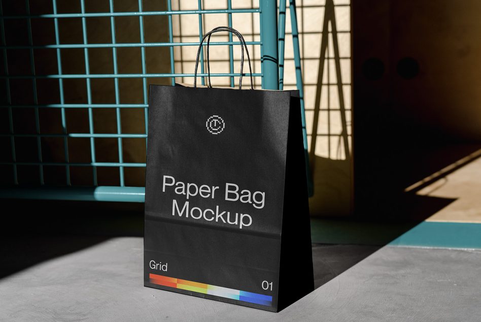 Black paper bag mockup with rainbow stripe on teal grid surface backdrop