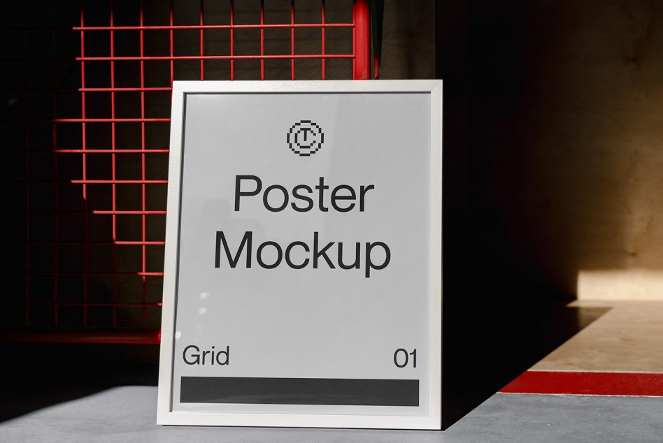 White framed poster leaning against red grid with dark interior backdrop
