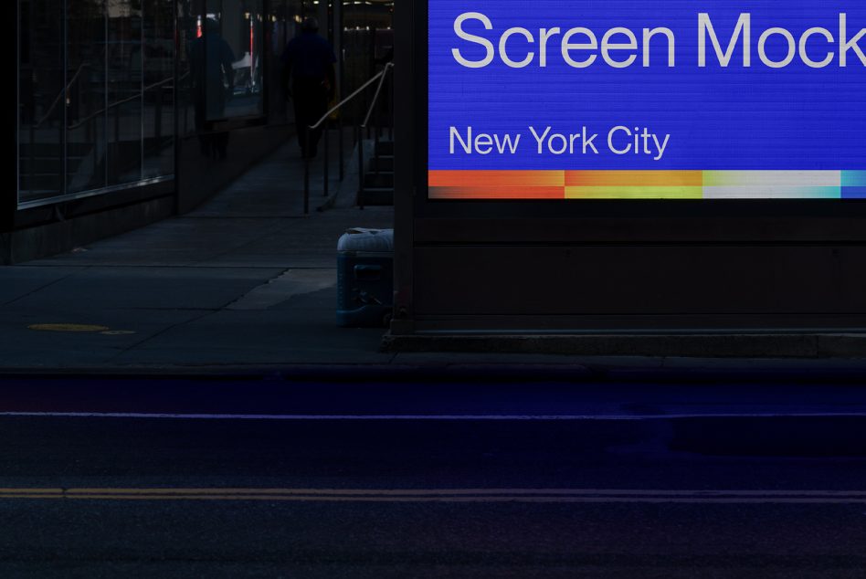 Large horizontal billboard at night showing blue screen with rainbow gradient at bottom