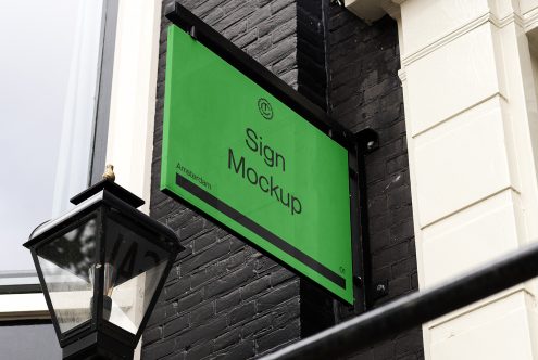 Bright green angled sign mounted on dark brick wall with metal bracket