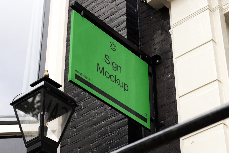 Bright green angled sign mounted on dark brick wall with metal bracket