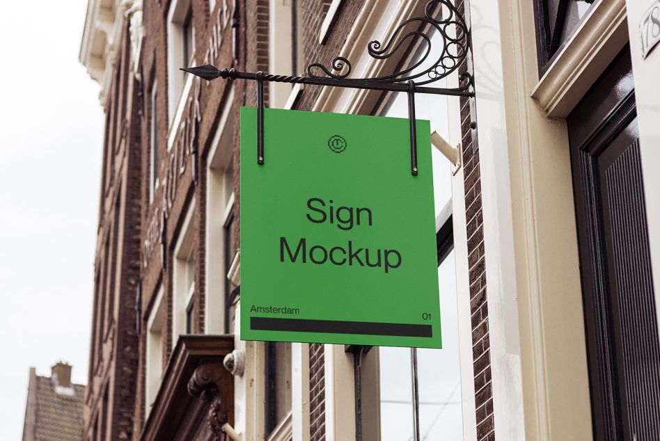 Bright green storefront sign hanging from ornate black bracket on brick building facade
