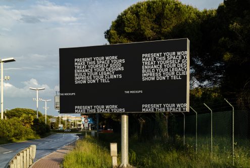 Outdoor billboard mockup by roadside with editable design space for graphic designers to showcase advertisement projects in a realistic setting.