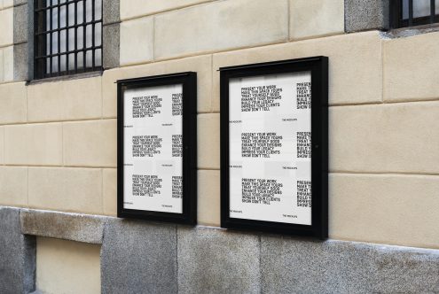 Two vertical black poster mockups on a beige wall with text overlay, ideal for showcasing graphic designs and typography in a realistic urban setting.