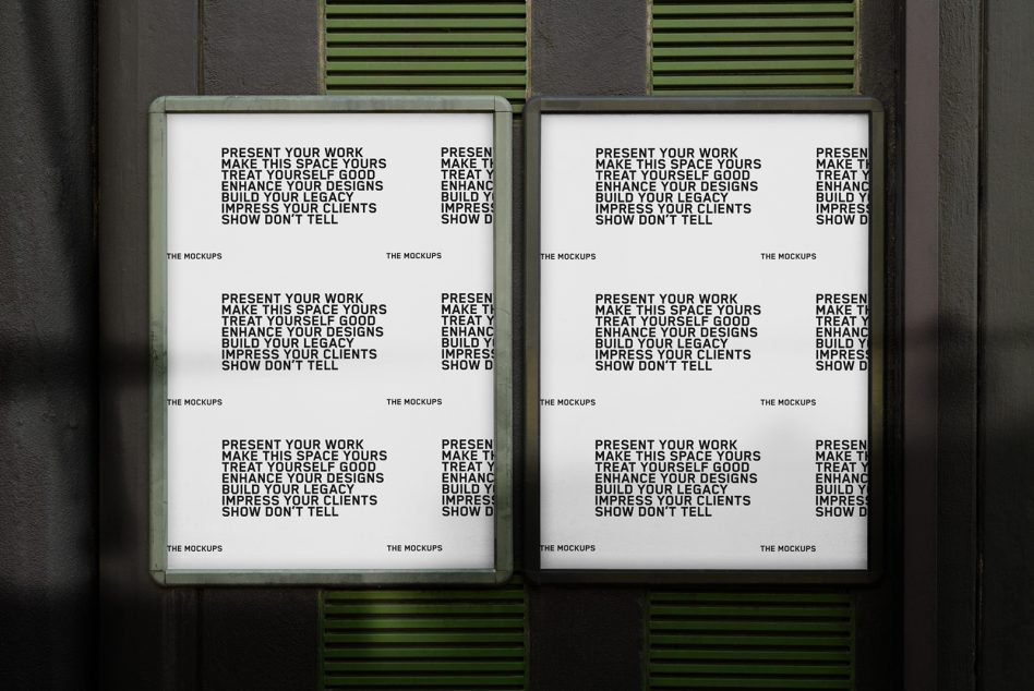 Two framed posters with green borders mounted on gray wall with green vents