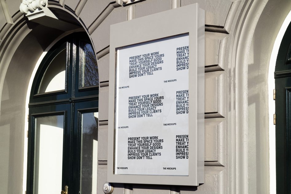 White framed poster mockup on building entrance with arched doorway in background