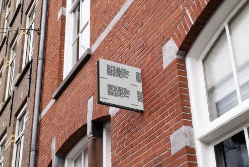 Square outdoor signboard mockup attached to a red brick building wall, ideal for displaying logo designs, branding, and shop signage for designers.