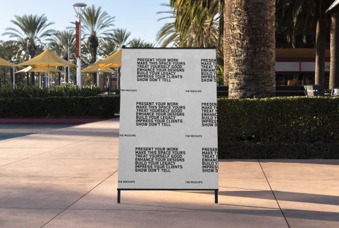 Outdoor advertising mockup panel in sunny park setting with palm trees, ideal for designers to showcase branding and signage designs.