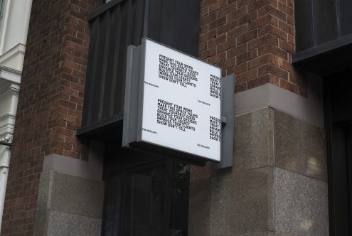 Outdoor signage mockup on a building corner with editable text for branding and logo design presentation.