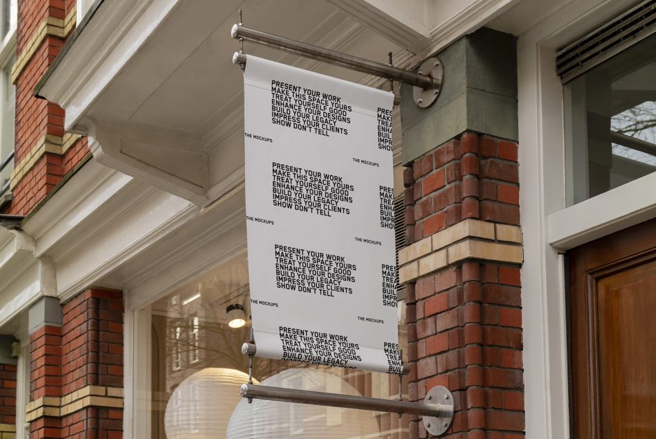 White fabric banner hanging from metal rod outside brick building entrance