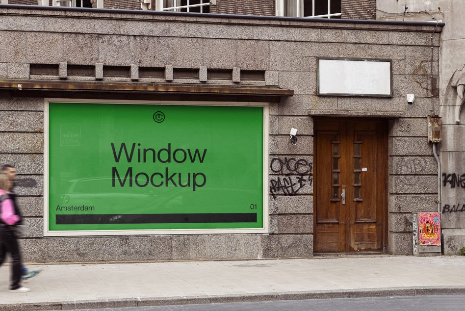 Bright green storefront window display on stone building with wooden door