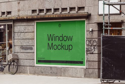 Bright green storefront window display with black text on stone building facade
