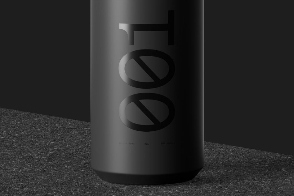 Black cylindrical soap bottle with embossed symbol on concrete surface