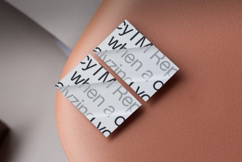 Overlapped business cards with serif typography on warm skin tone