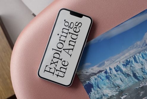 iPhone on pink surface displaying serif typography saying Explore the Andes