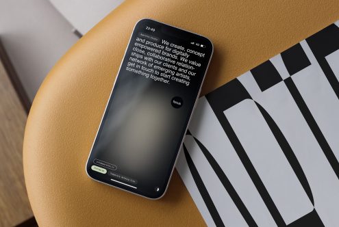 iPhone on tan surface showing dark app interface with body copy over geometric pattern