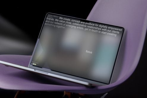 Laptop mockup on purple curved surface showing website with blurred content text