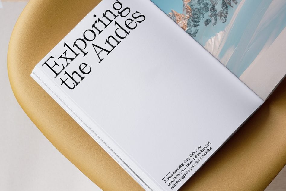 Open book with serif typography on gold circle, mountain landscape photo peeking from pages