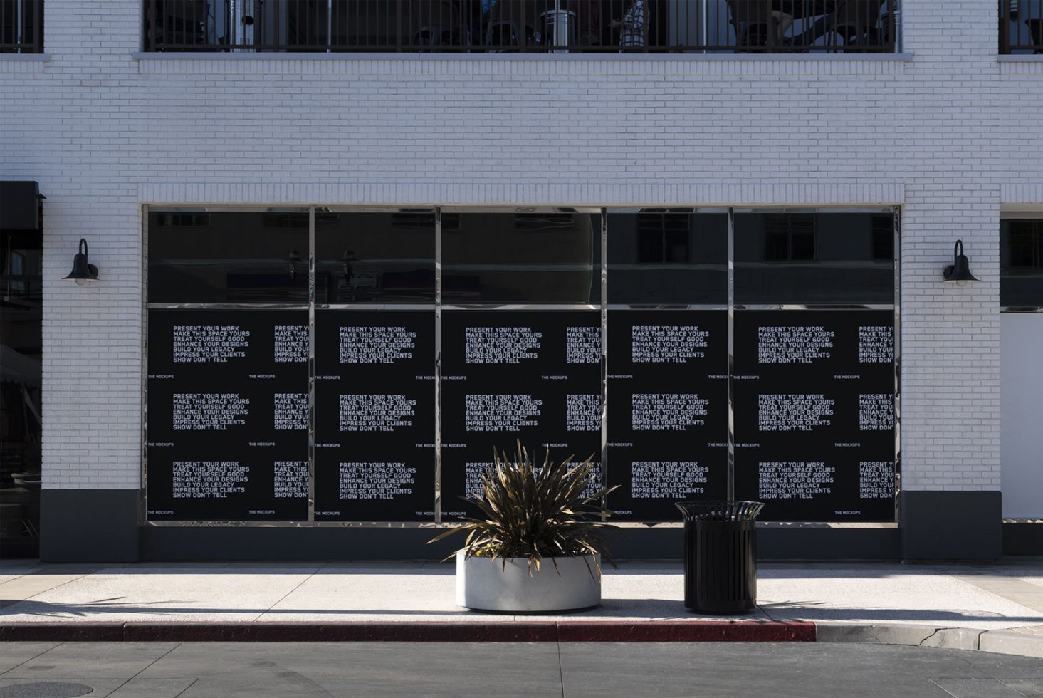 Street-level mockup of posters with text graphics on a modern building's windows for showcasing design projects to potential clients.