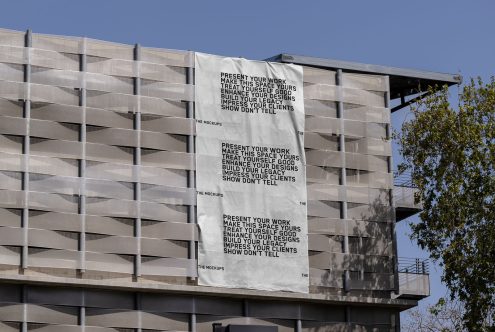 Building exterior with a large hanging banner mockup showcasing design, great for presenting graphic work to clients, clear blue sky.