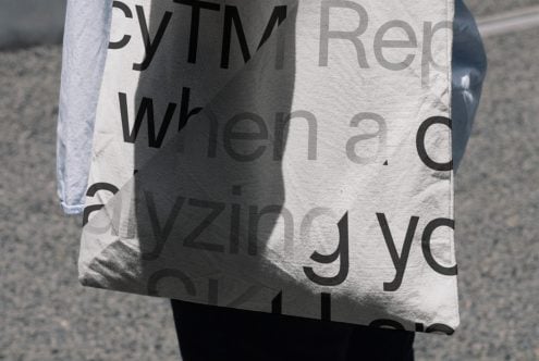 Close up of canvas tote showing large sans serif text with shadow effect