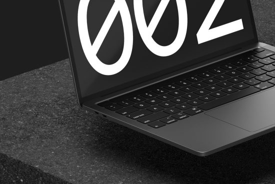 Laptop with minimalistic design logo on screen placed on a textured surface, representing digital mockups for professional designers.