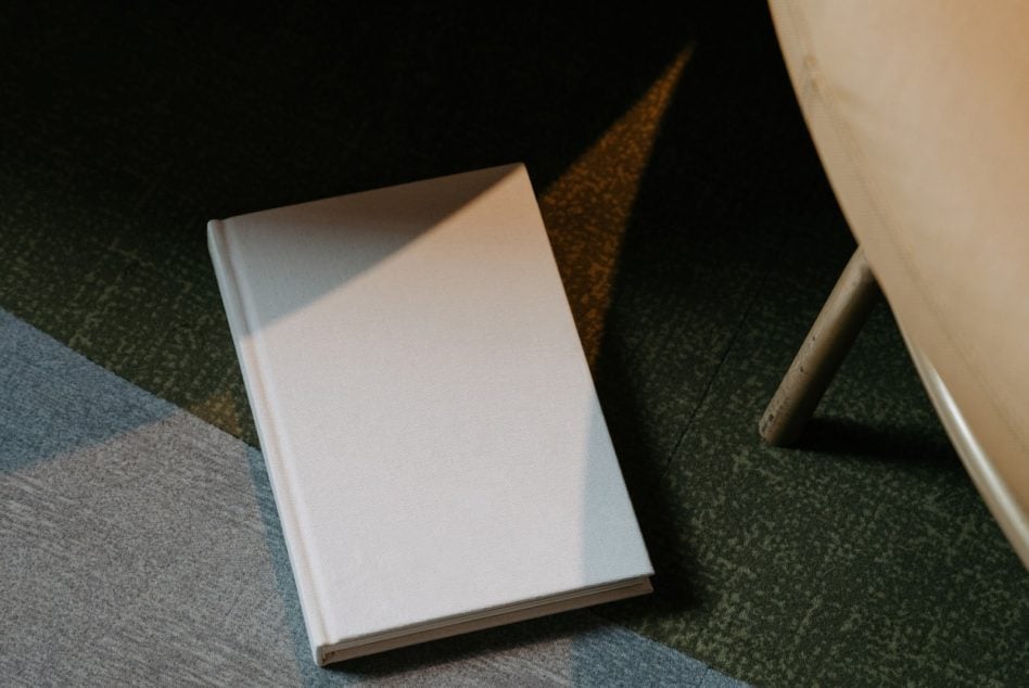 Book mockup interior pages displayed on blue green fabric backdrop
