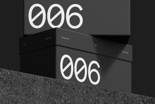 Black packaging box mockup with white branding for product design, placed on a textured surface, ideal for presentations and portfolios.