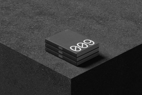 Stack of black business cards with white modern design on textured surface for graphic designers, ideal for mockups and branding display.