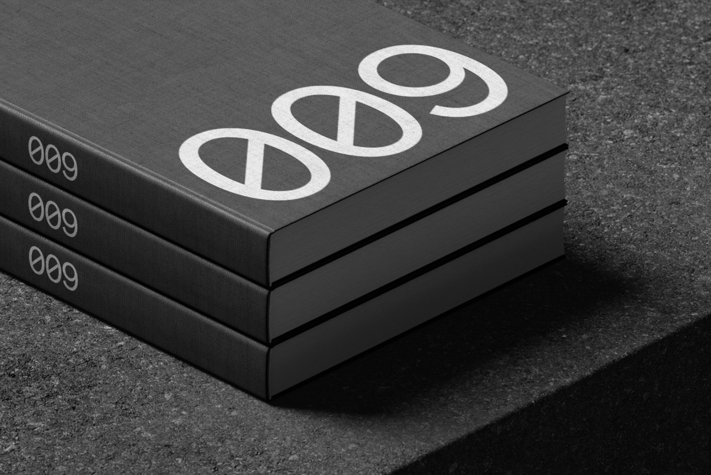 Stack of three black hardcover books with silver peace symbol and numbers mockup on textured surface for graphic designers.