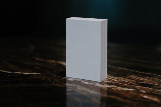 Blank book mockup standing upright on a wooden surface with dark background, ideal for showcasing cover designs and branding.
