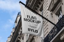 White flag hanging on Parisian building facade with FLAG MOCKUP text
