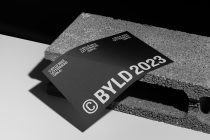 Black business card mockup on textured concrete surface with white typography