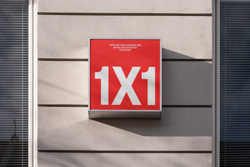 Red square storefront sign with white 1X1 text mounted on concrete building