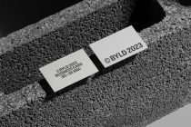 Two white business cards displayed on grainy concrete with deep shadows