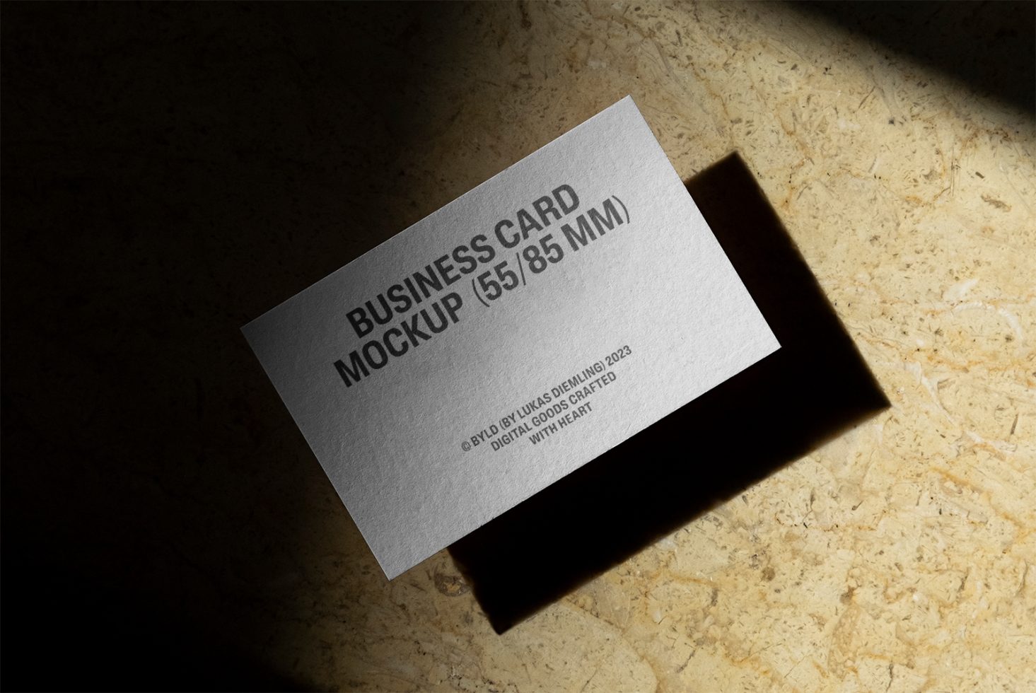 Elegant business card mockup with natural shadows on textured background, ideal for showcasing professional designs to clients, available in PSD.