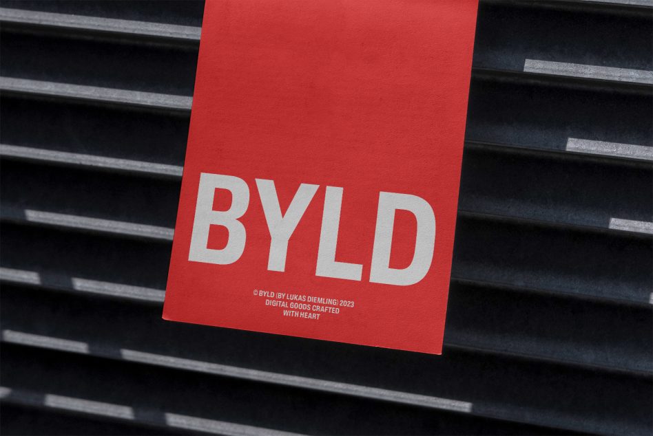 Bright red DIN A format card displayed against dark ribbed metal surface