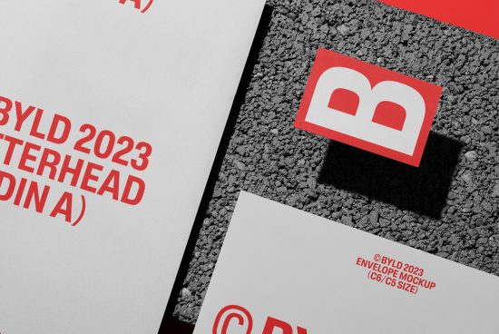 Creative letterhead and envelope mockup featuring brand identity design, with red logo, on textured background for designers' portfolio display.