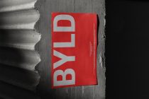 Red poster mockup on concrete wall with sculptural light shadows
