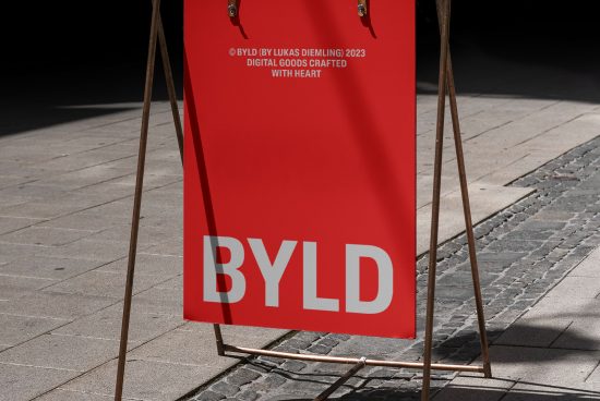 Outdoor advertising mockup featuring a sandwich board with red background and white text visible on a sunny day, suitable for designer presentations.