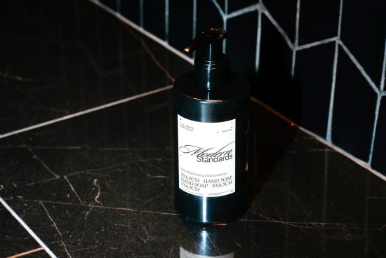 Elegant black hand soap bottle mockup with white label design on dark tiled background, perfect for personal care product presentation.