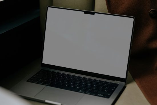 Laptop mockup on a desk with a blank screen for design presentation. Modern notebook for showcasing web graphics and templates.