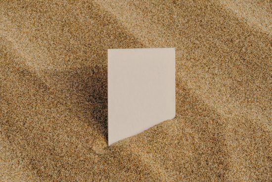 Blank paper card mockup on sandy texture, ideal for beach-themed graphic design or branding presentations for designers.