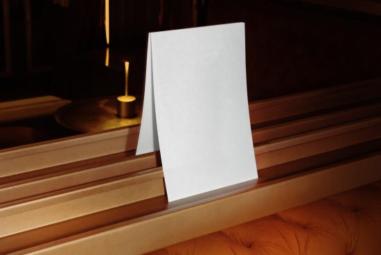 Elegant blank card mockup on golden seat with warm ambient lighting, ideal for sophisticated invitation design presentations.