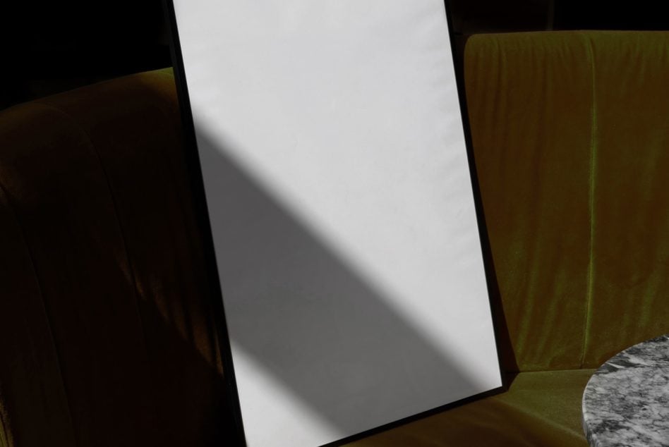 Blank poster back side mockup angled on olive velvet furniture with shadows
