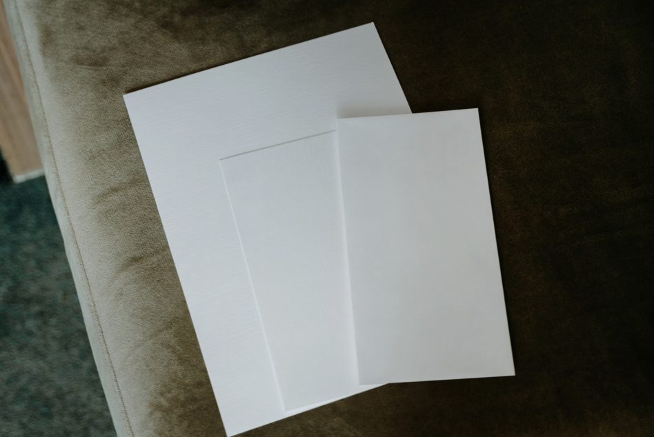 Opened tri-fold brochure mockup with blank white pages on textured fabric
