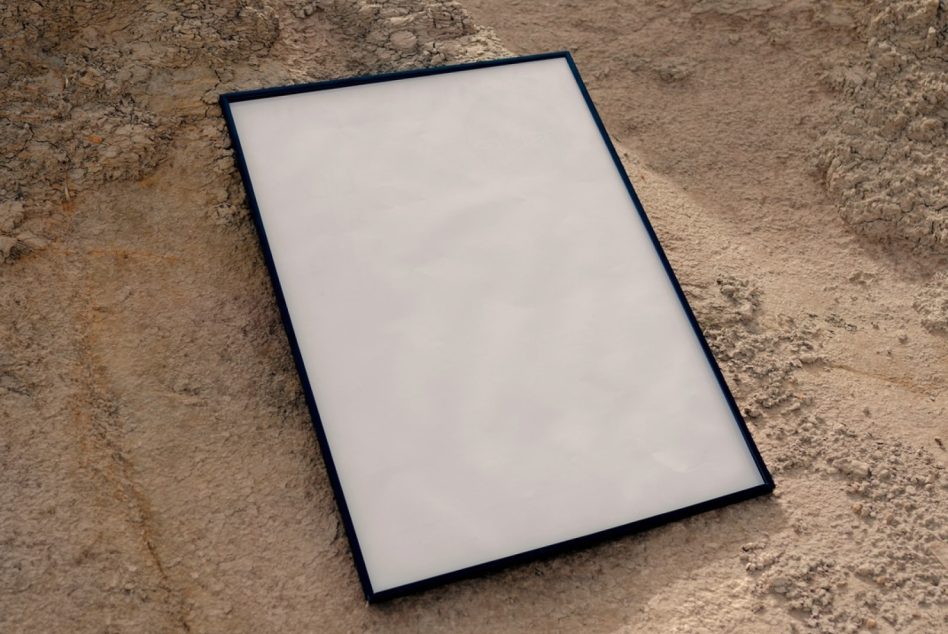 Blank framed poster mockup on textured concrete ground